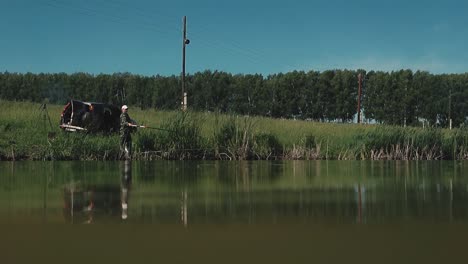 fisherman sits on the shore of the lake 1