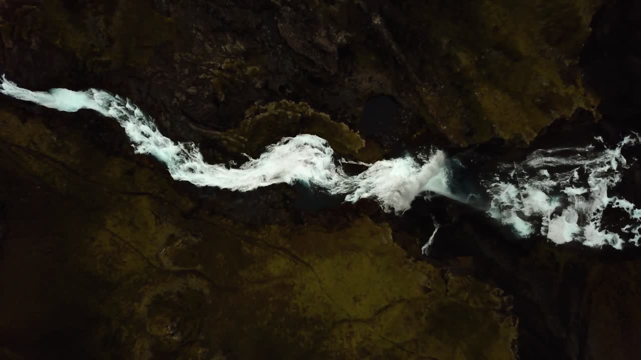 Veduta aerea dall'alto in ascesa sopra l'acqua che scorre dalla cascata di Ófærufoss, negli altipiani dell'Islanda.