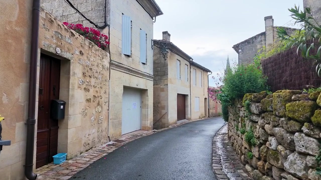 A slow camera movement travels down a quiet cobblestone street past traditional stone houses