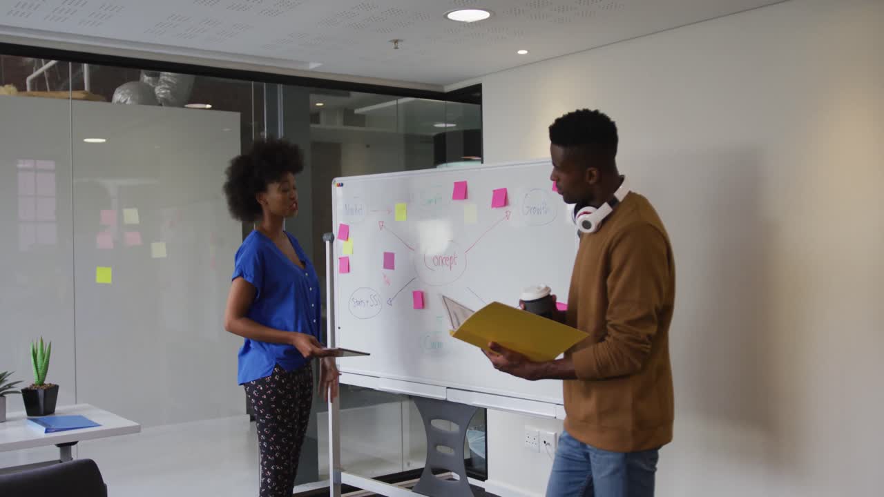African american male and female business colleagues brainstorming in meeting room