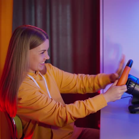 woman playing car race on her computer. girl uses a racing steering wheel while playing video games. gaming and entertainment concept.