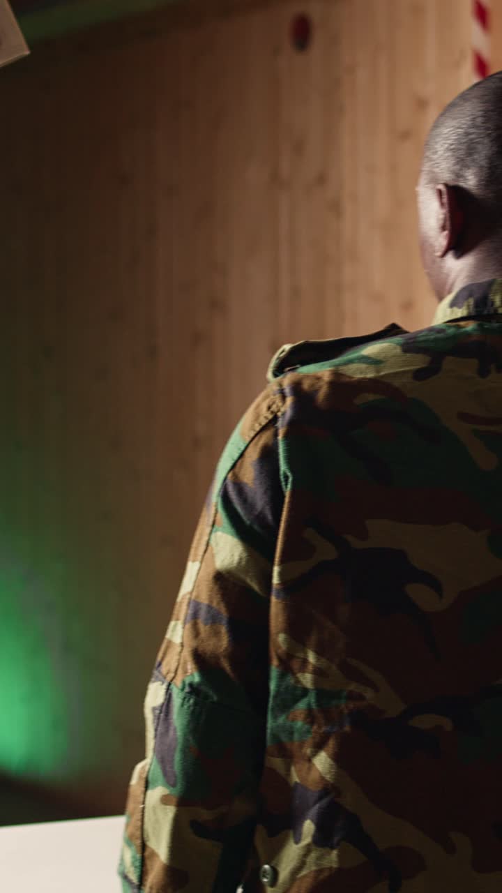 Vertical video Soldier training with weapon cheering after managing to accurately hit bullseye