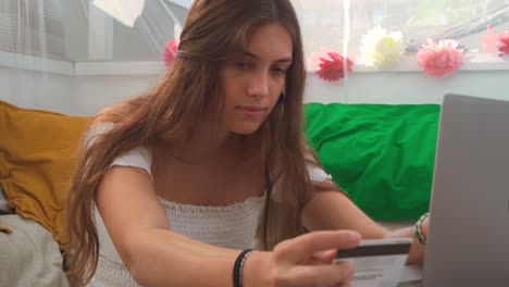 cheerful woman paying for order with plastic card during online shopping