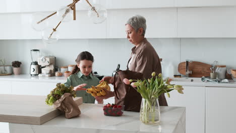 grandma and girl unpacking groceries