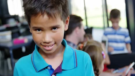 Portrait-of-happy-schoolboy-smiling-in-classroom