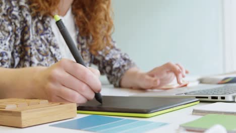 mujer de negocios usando una tableta gráfica y operando una computadora portátil 4k