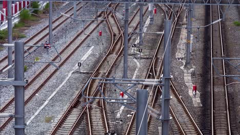 un solo vagón de tren que se mueve lentamente recto hacia adelante en el medio de las vías, y desaparece del marco