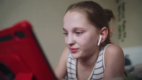 teenage girl using tablet and earbuds