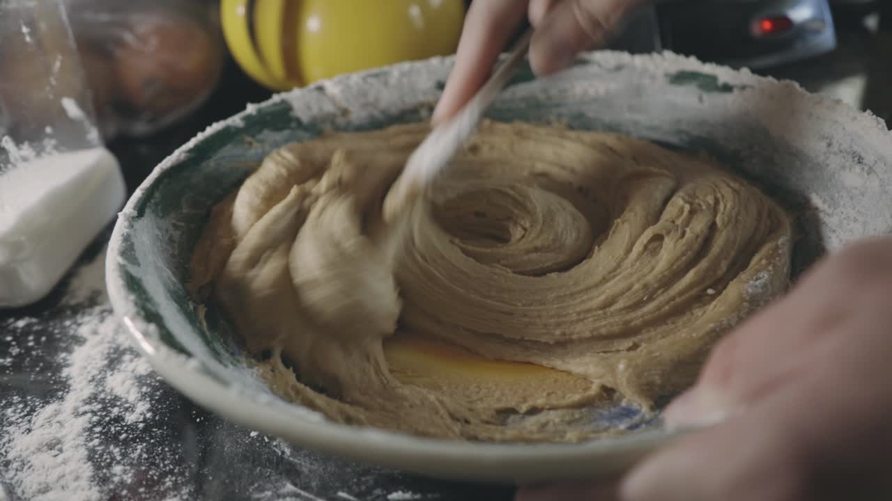 Mixing Thick Cookie Batter In A Bowl With Wooden Spoon - close up