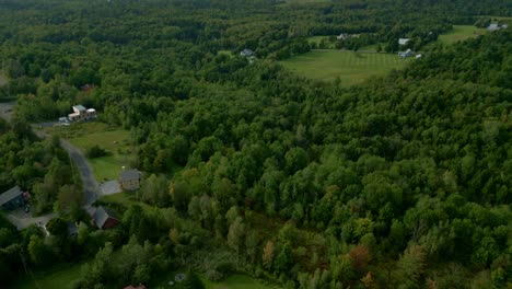 drone flies over town birdseye view from luxury home with pool to breathtaking aerial view of sutton, quebec’s vast green landscape, nature’s beauty and tranquility.