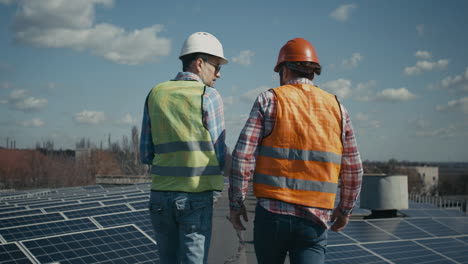 workers inspecting rooftop solar panels