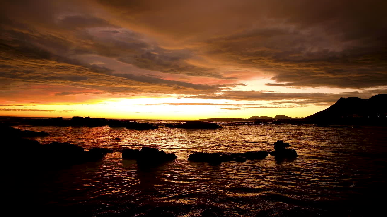 日没後の燃えるような空、鮮やかなオレンジ色の雲の黄金の時間、海の反射