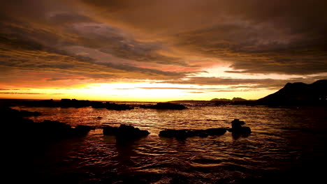 sky on fire after sunset, vibrant orange clouds golden hour, ocean reflection