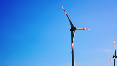 wind turbines in blue sky. wind turbines spin under a clear blue sky, harnessing renewable energy in an open landscape