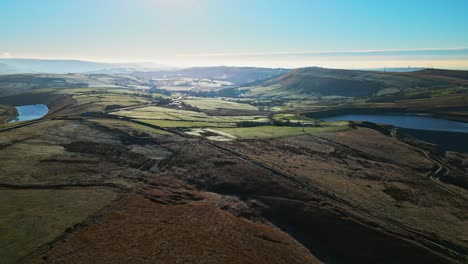 Tiefschwebende-Luftaufnahmen,-Die-In-Die-Sonne-Fliegen-Und-über-Goldene-Moorlandschaften,-Die-Mit-Frost-übersät-Sind,-Direkt-Auf-Einen-See-Zu,-Stausee-In-Der-Ferne