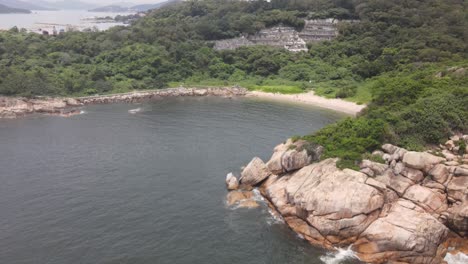 aerial rising shot from rocky coastline to reveal island view of cheung chau in hong kong