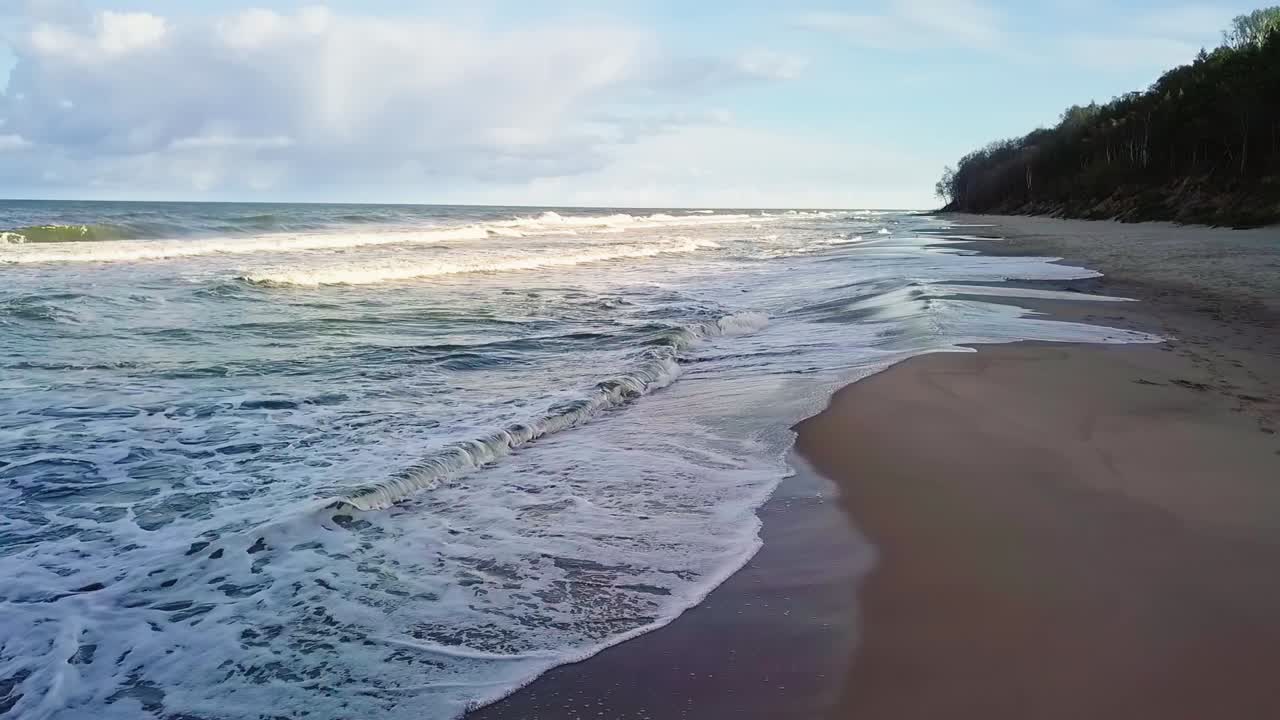 olas del mar en la playa de arena toma aérea en cámara lenta