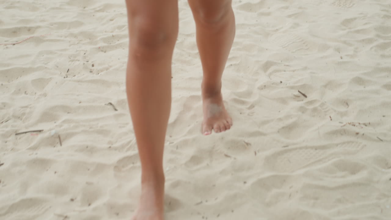 Donna energica fa jogging sul litorale. Esercizio veloce a piedi nudi in riva al mare durante l'estate. Atleta dinamica esegue una routine di jogging energica su una spiaggia sabbiosa con clima caldo.