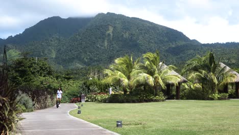 woman rides electric vehicle in front of a mountain in the caribbean