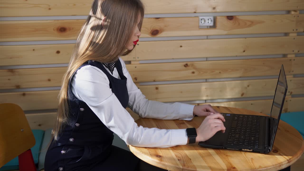 mujer trabajando en una computadora portátil en un café