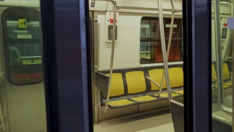 entering of a subway wagon in mexico city at a station on sunday morning, with few people, view frome wagon interior