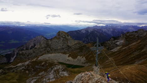 Vista-De-Los-Alpes-Y-La-Cruz-De-La-Cima-De-La-Montaña-Rofanspitze-En-Los-Alpes-Austriacos-En-Un-Día-Nublado