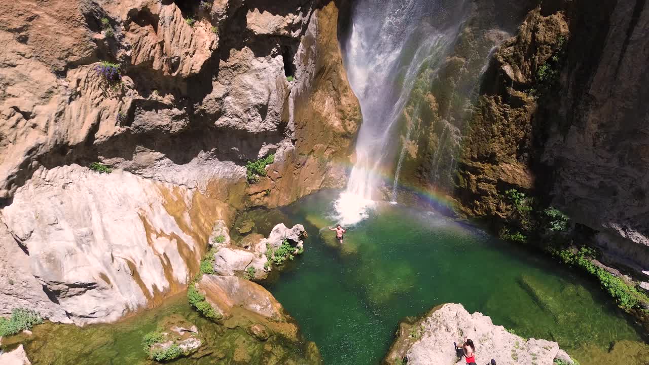 Aerial View of Stunning Waterfall with Swimmers