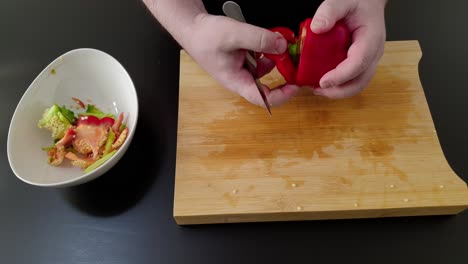 preparing red bell pepper, cutting and removing seeds and core, high angle studio shot