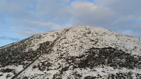 Snowy-winter-countryside-mountain-valley-panoramic-Welsh-hiking-national-park-aerial-rising-tilt-up-to-peak-view