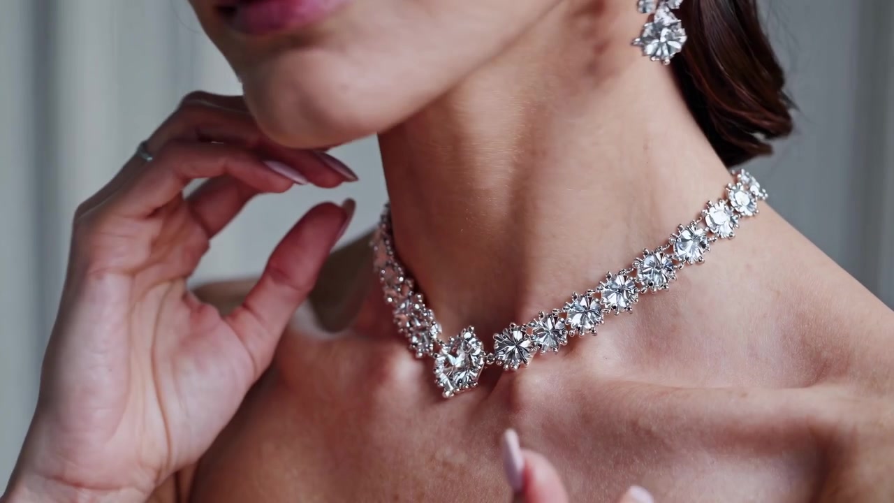 Donna elegante che si sistema la collana e gli orecchini di diamanti