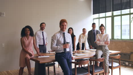 Corporate-business-team-smiling-to-camera-in-a-meeting-room