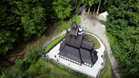 Aerial-view-around-the-Stave-church-in-sunny-Fantoft,-Norway---high-angle,-orbit,-drone-shot