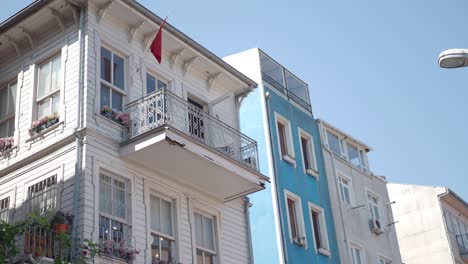 a white building with a balcony and a red flag