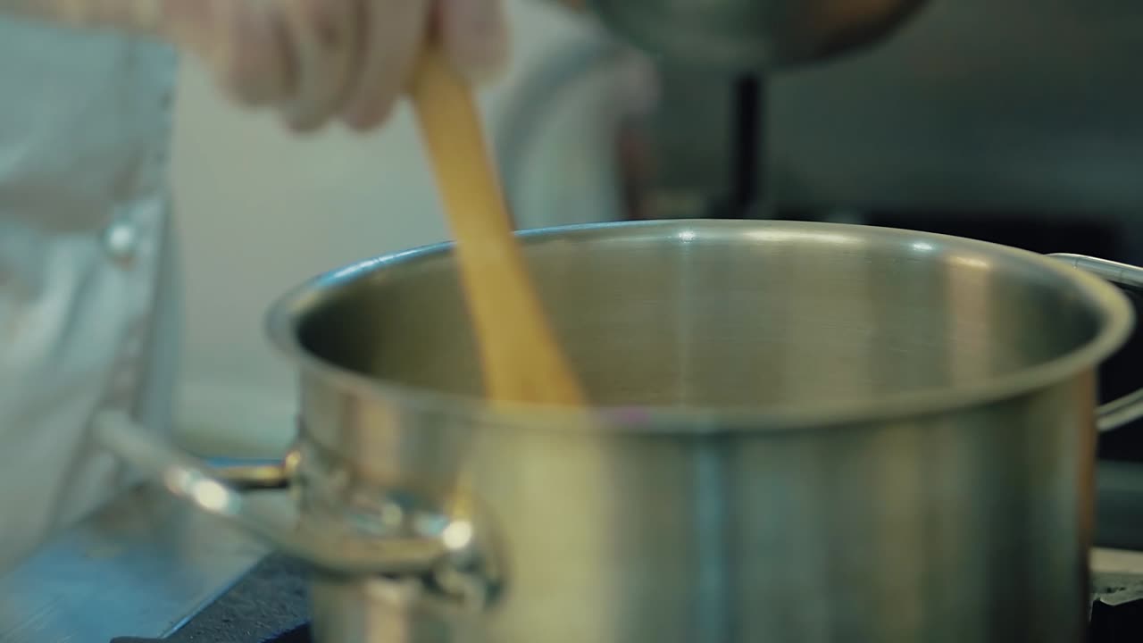 el cocinero vierte la harina para hacer la masa en una sartén y luego la mezcla con una espátula