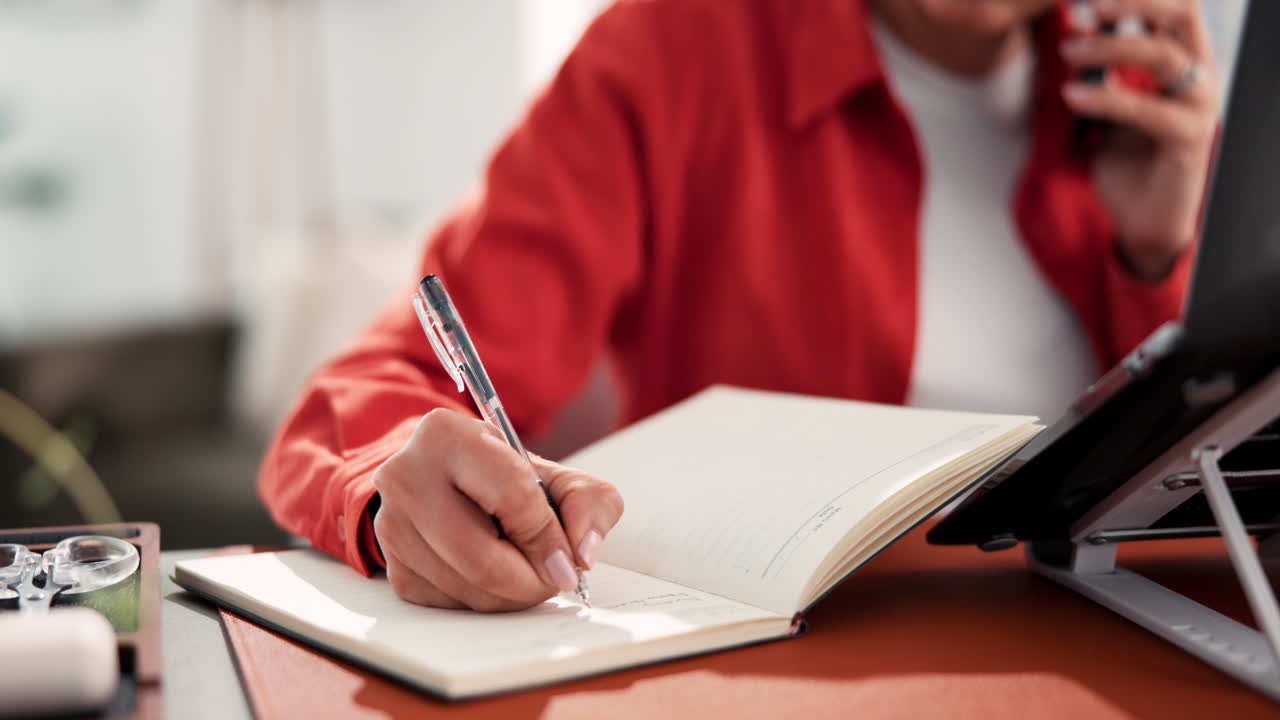 Woman Writing in Notebook at Desk
