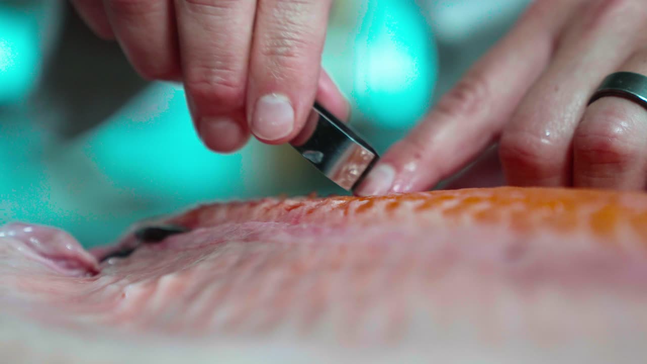 A static up-close shot captures a chef carefully removing fish bones, showcasing his precision and expertise. Ideal for culinary, seafood, and professional kitchen content.