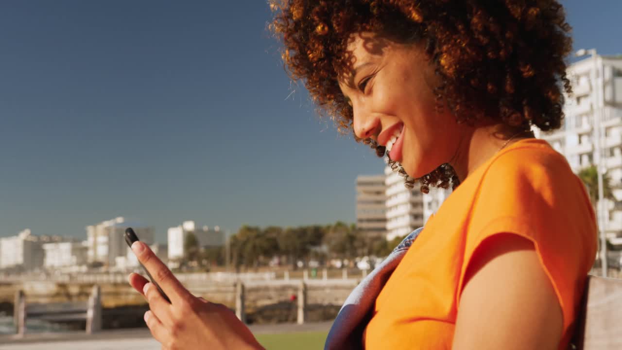mujer sonriendo y usando el teléfono