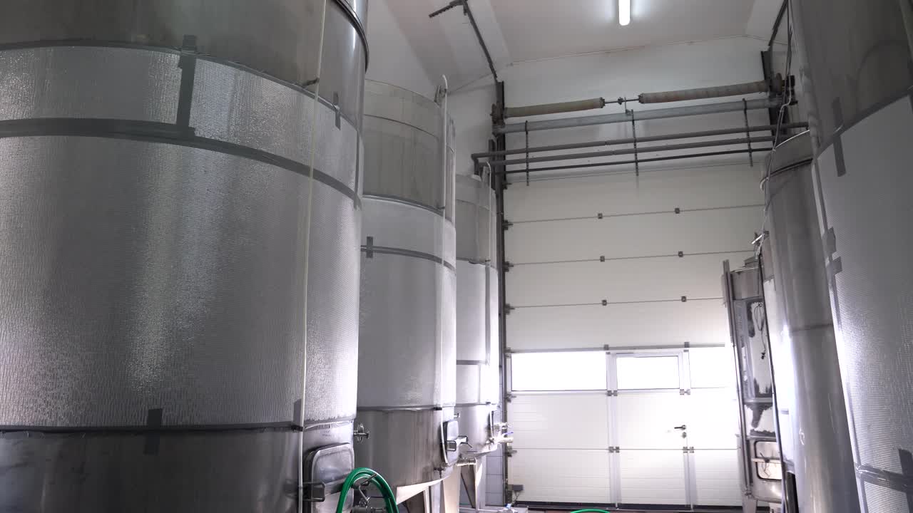 Large stainless steel wine fermentation tanks in processing area
