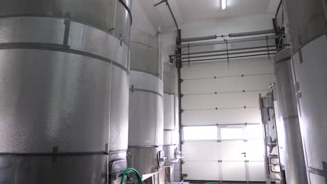 large stainless steel wine fermentation tanks in processing area