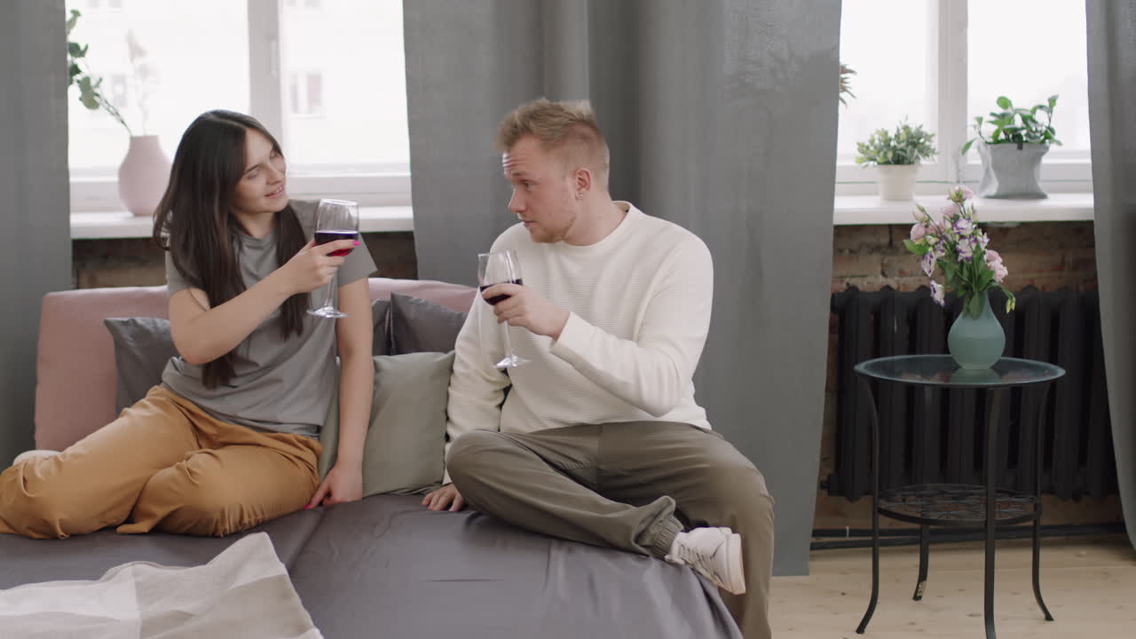 Unge par, der skåler med rødvin