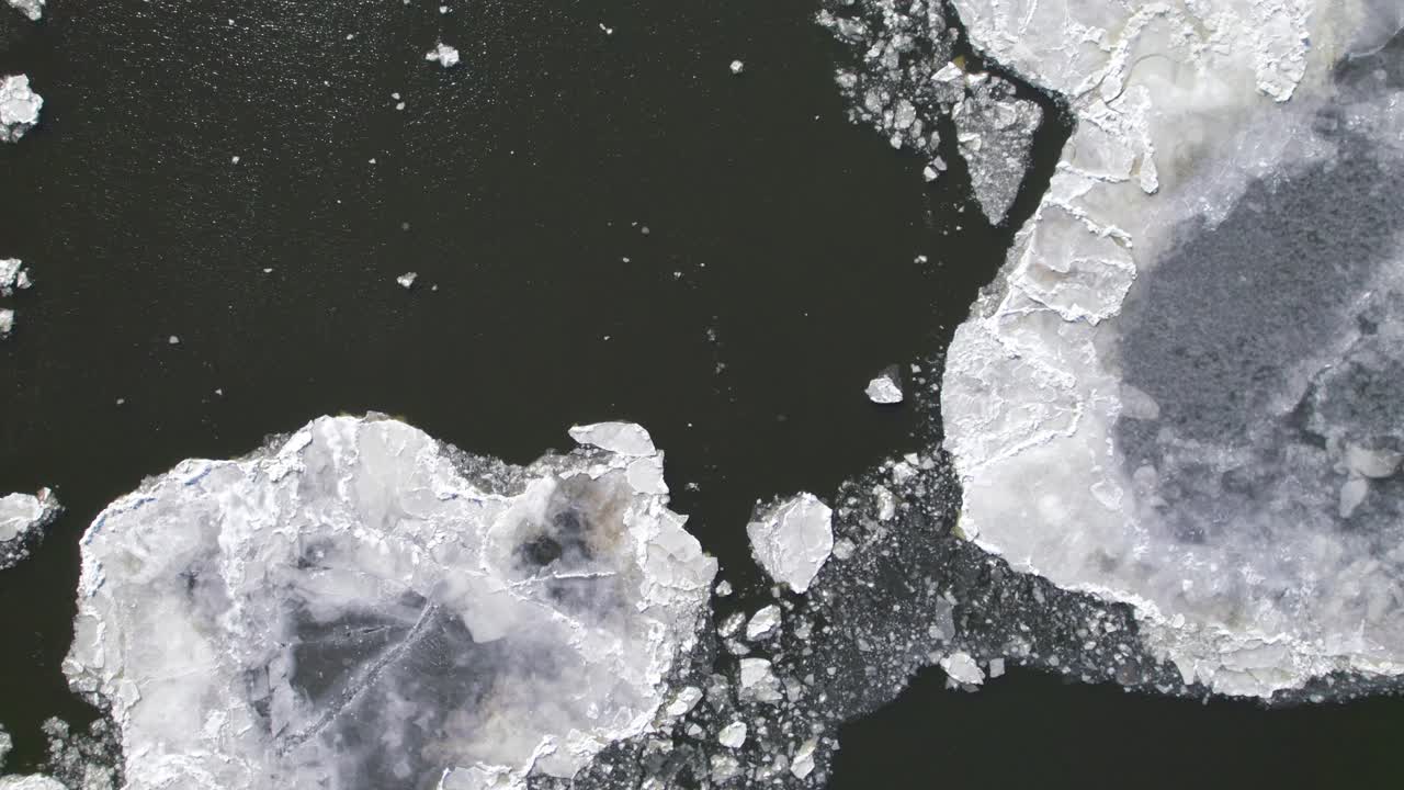 Overhead of a river with icebergs and open water, smooth drone screensaver type footage, 4K