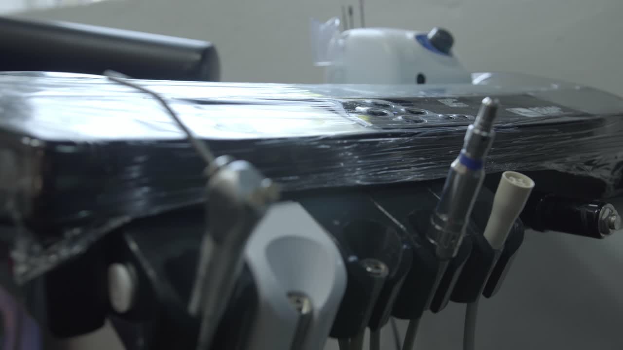 Zoom in view of dental instruments attached to a dentist chair inside a clinical environment