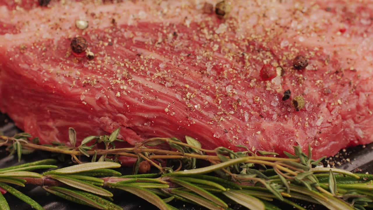 Close-up of seasoned raw beef steak with herbs