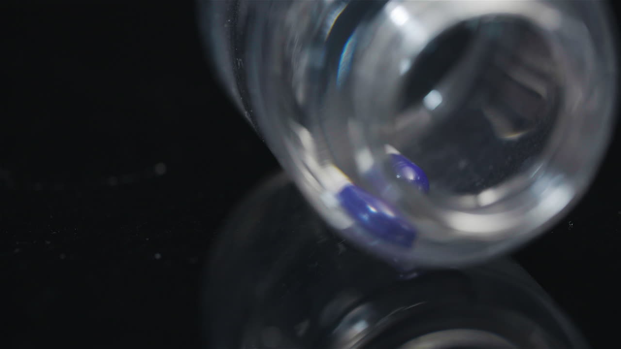 검은색 배경에서 회전하는 작은 병에 든 단일 의료 알약 2