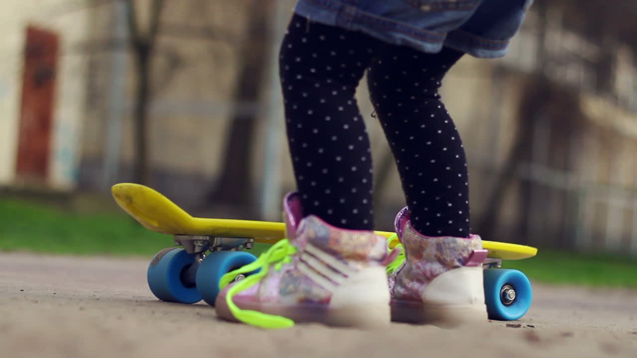 Children playing with skateboard and trying to ride. Kids having fun outdoor