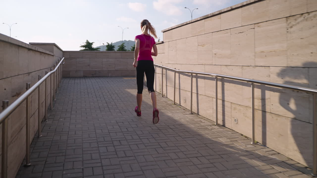 mujer corriendo por el camino urbano