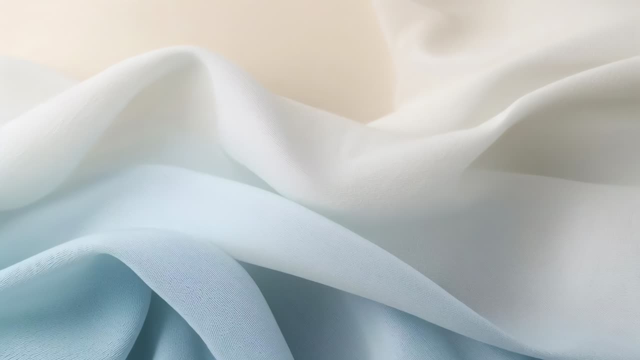 Shifting layered pale-blue and white fabric forming gentle waves in studio closeup, diffuse light