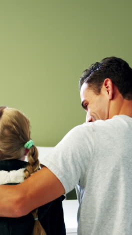 padre e hija sentados en una cama médica en el hospital
