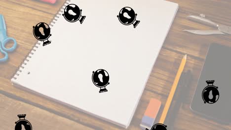 múltiples iconos del globo cayendo contra el equipo de concepto de la escuela en una mesa de madera
