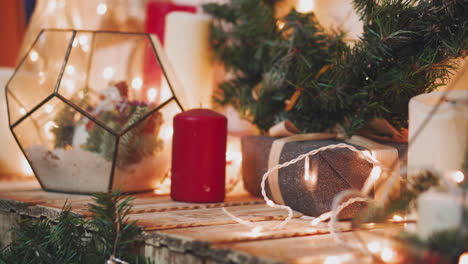 pasatiempo creativo. envoltorio de regalo. embalaje de modernas cajas de regalo de navidad en elegante papel gris con cinta roja satinada. vista superior de las manos sobre una mesa de madera blanca con ramas de abeto, decoración